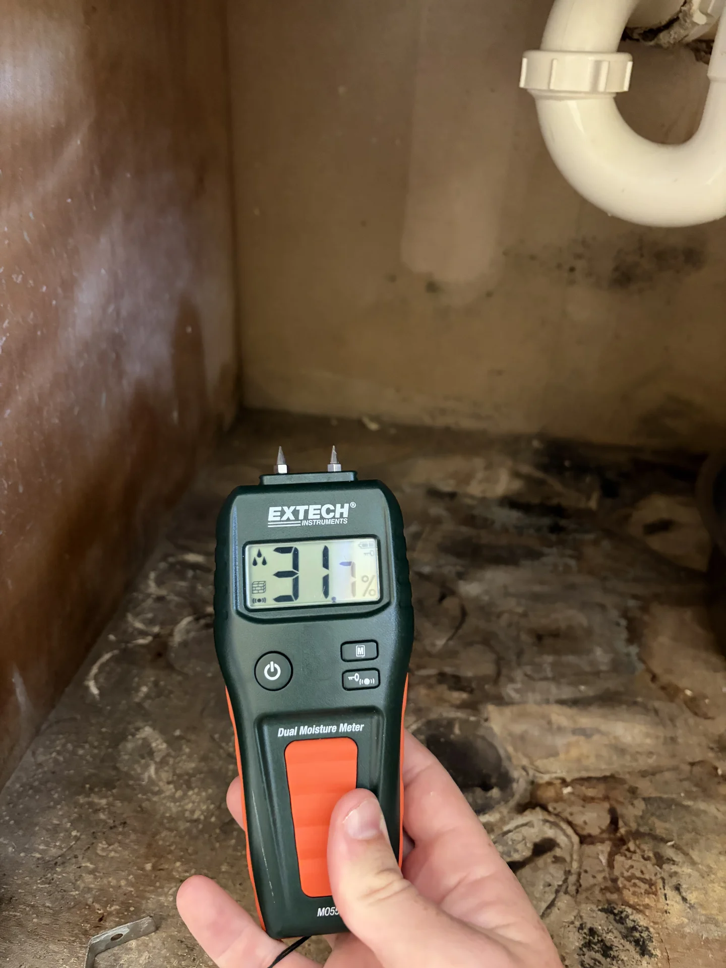Comparative moisture reading of 31.7 on damaged bathroom cabinet floor