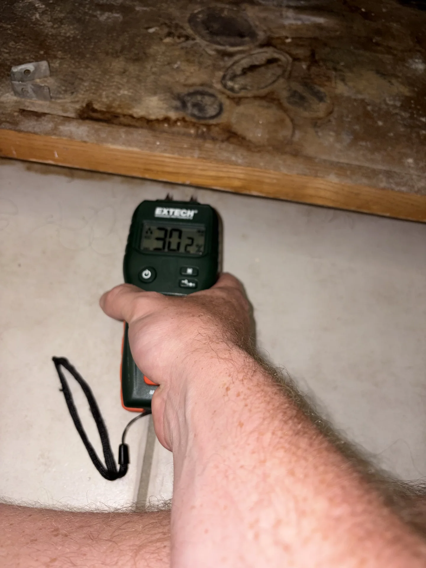 Wet cabinet toe kick with comparative moisture reading of 30.2