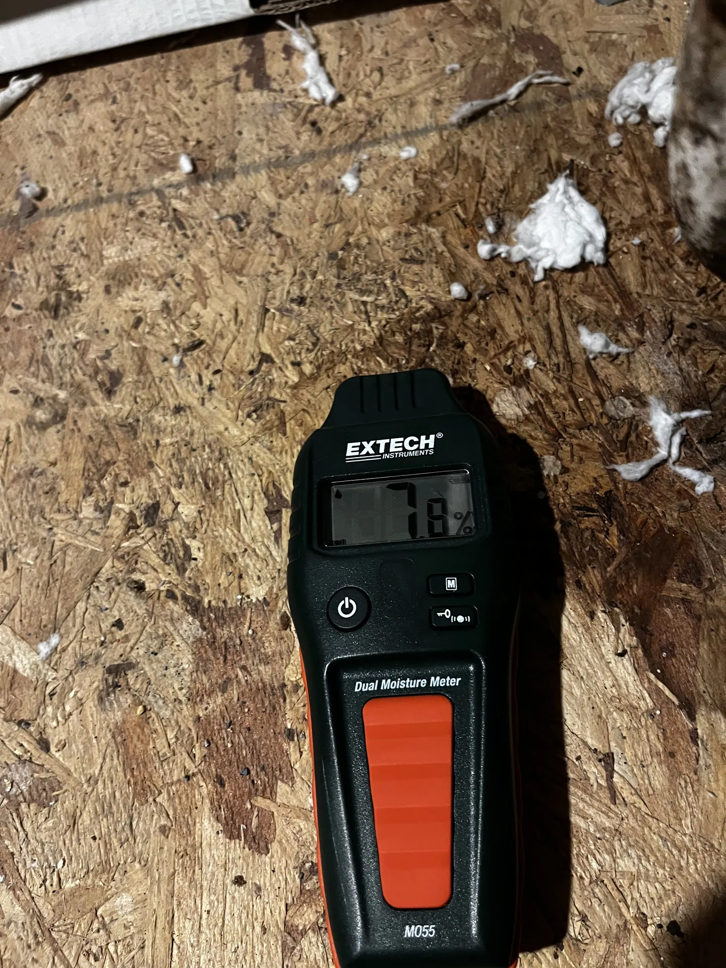 Comparative moisture-meter display reading 7.8 at visually unaffected reference decking