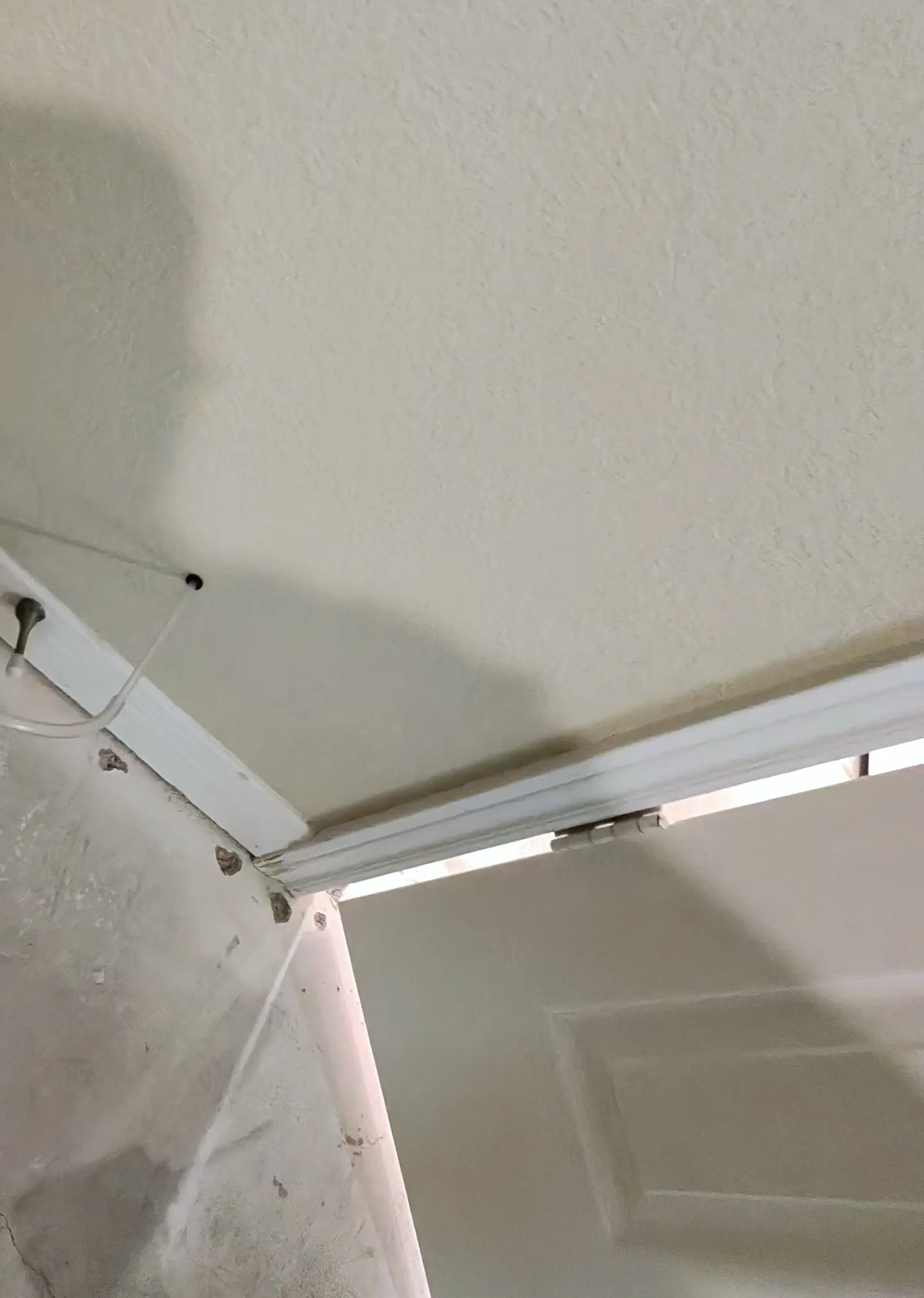Master-closet corner with removed flooring and exposed concrete slab after a prior water event