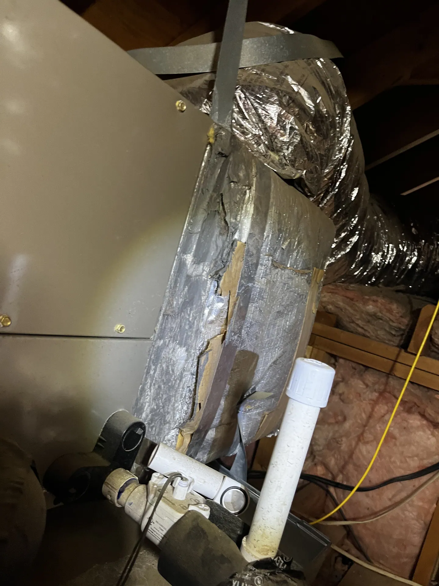 Damaged duct jacket and exposed insulation near the air-handler connection for the playroom branch