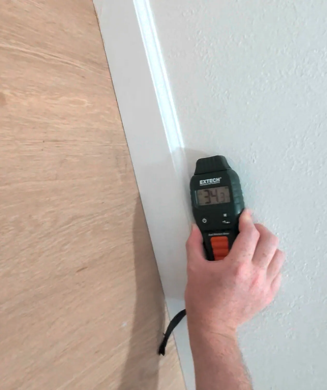 Comparative moisture response of 34.3 on drywall at the floor line behind a former exterior brick wall