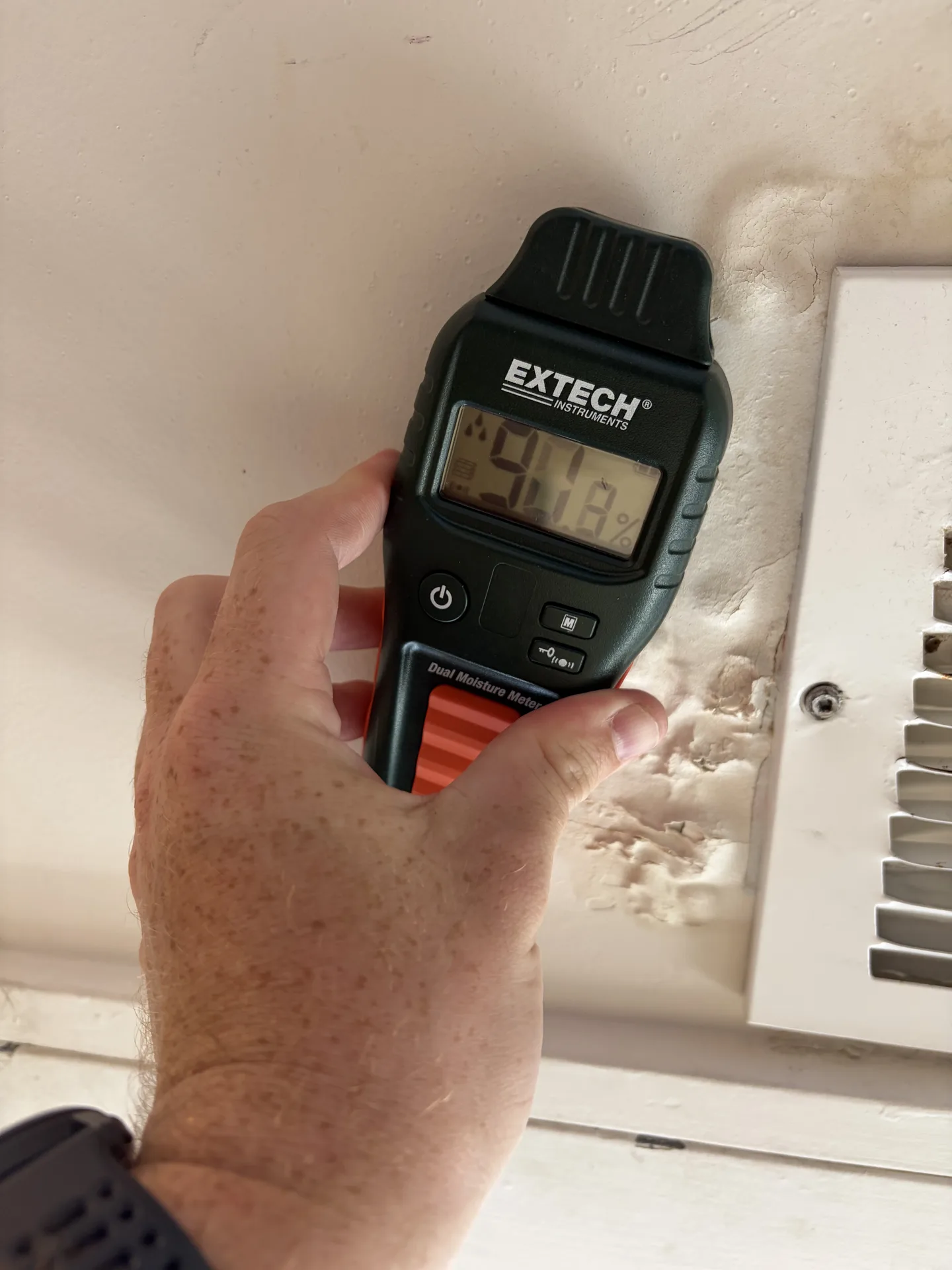 Comparative pinless moisture reading of 90.8 on the opposite side of the HVAC supply register