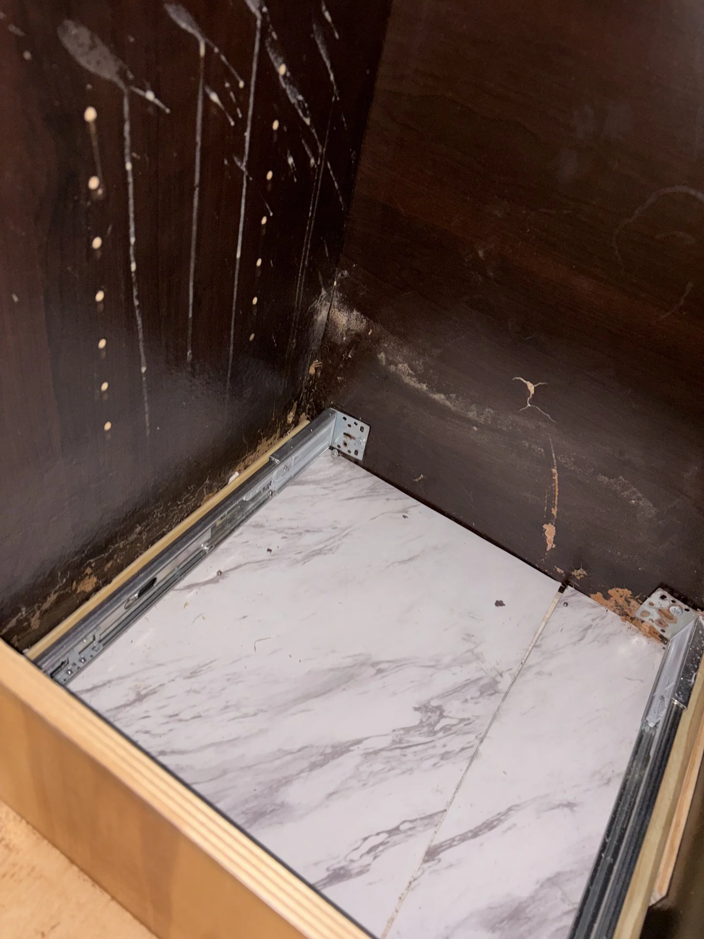 Dark discoloration in kitchen-island drawer bay next to sink cabinet