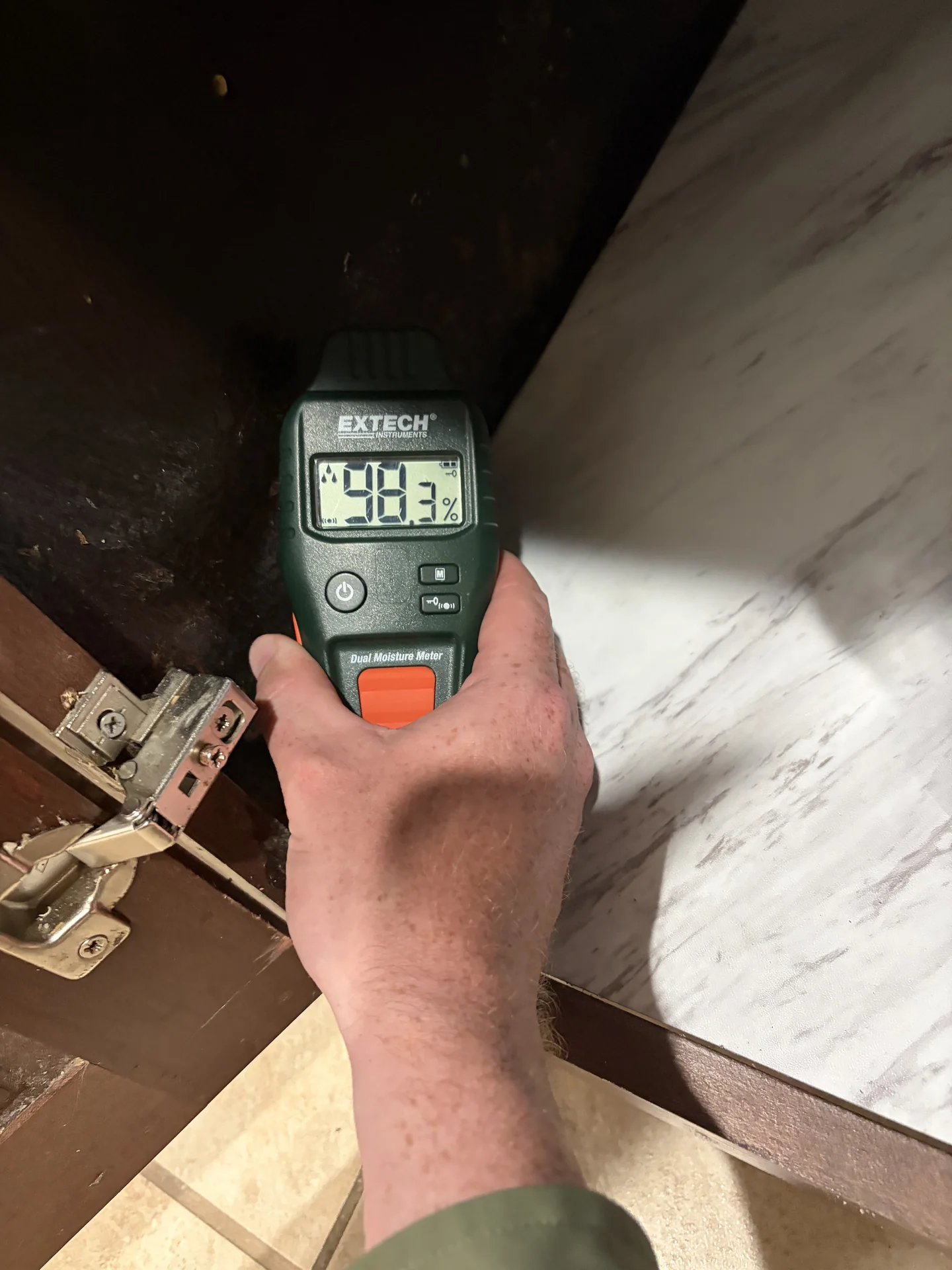 High comparative moisture reading on wet sink-base cabinet panel