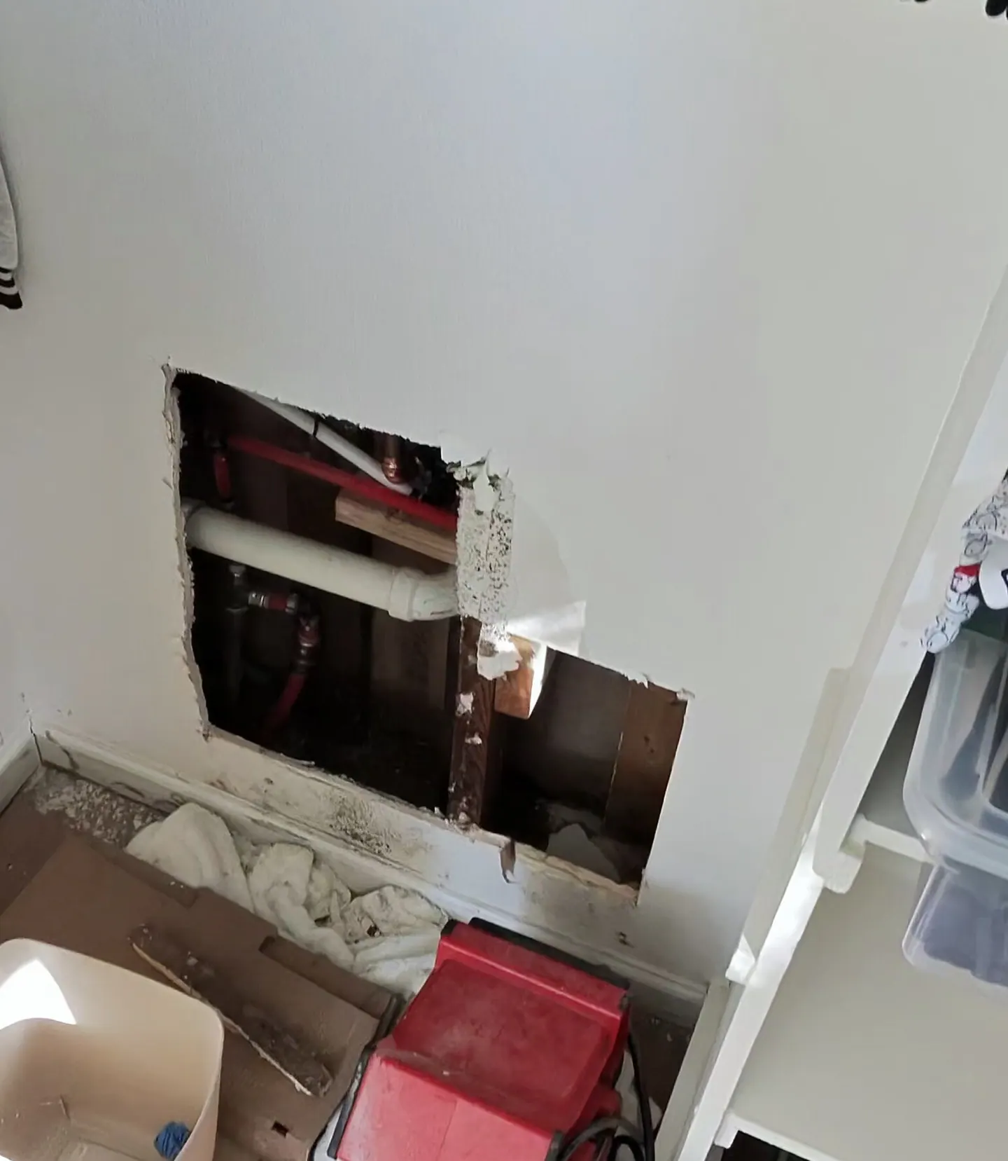 Existing repair opening exposing stained wallboard and framing inside a guest bedroom closet